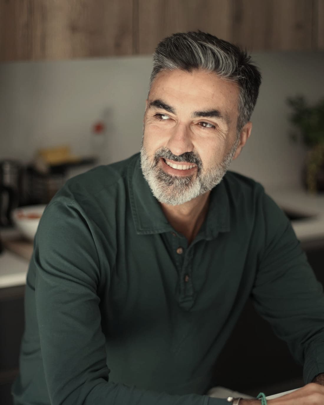 A business owner leaning on a kitchen counter, mid conversation
